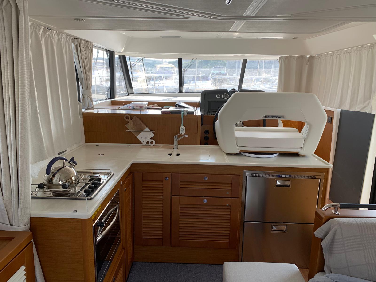 BANDAMA salon interior with teak floors, dining banquette, and helm station